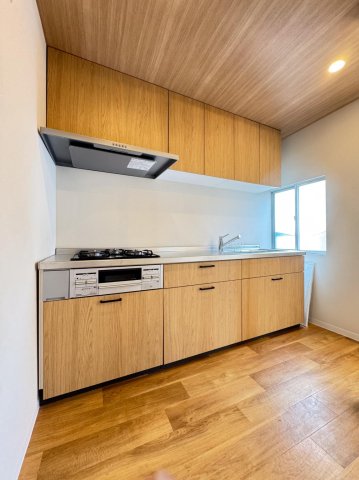 デザイナーズリノベ戸建て 木目の収納力のあるシステムキッチン