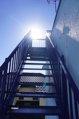 高明ビル302号室 東側窓から見える階段は屋上につながっています