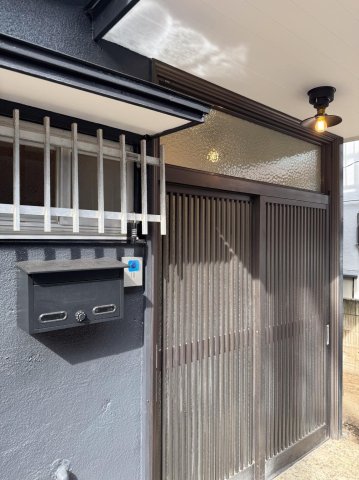 デザイナーズリノベ戸建て 外観は濃いグレー　玄関照明もカフェのよう