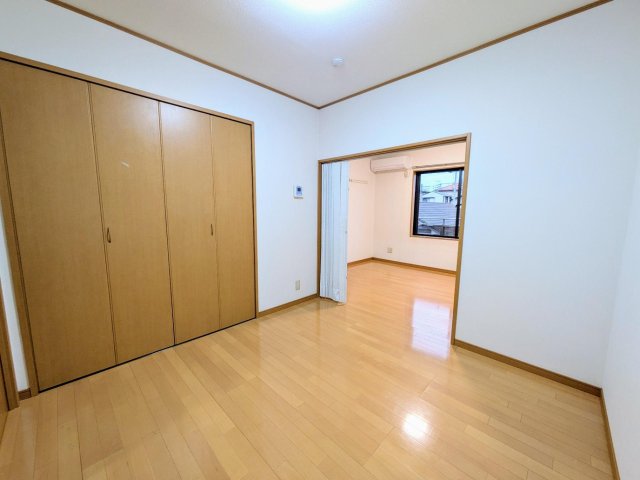 コーポKⅡ102号室 洋室。キッチンとリビングの間のお部屋も広々。フローリング。